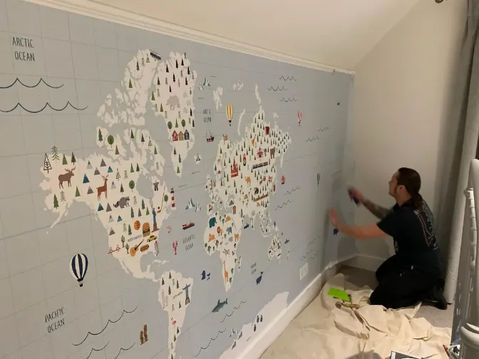 men wallpapering room walls