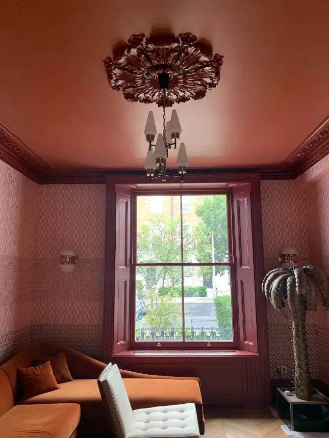 dark pink wallpaper on the walls and dark pink paint on ceiling and wood