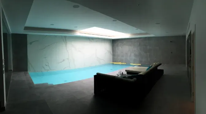 large room, gray walls and floor, gray sofa in the middle